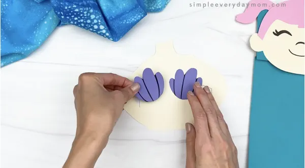 hand gluing seashells to paper bag mermaid craft