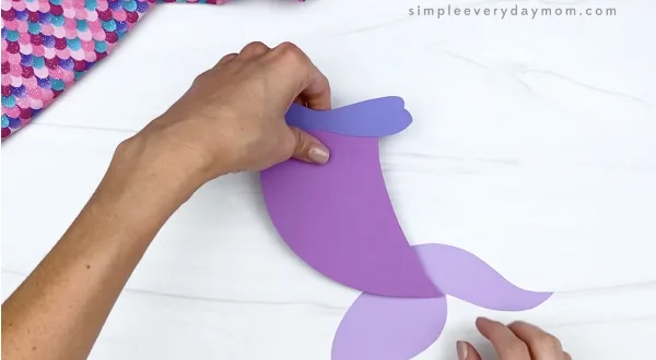 hand gluing fin to mermaid paper craft