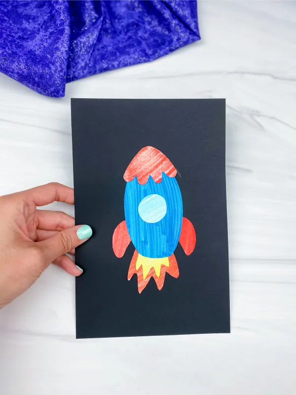 hand holding cut and paste rocket craft