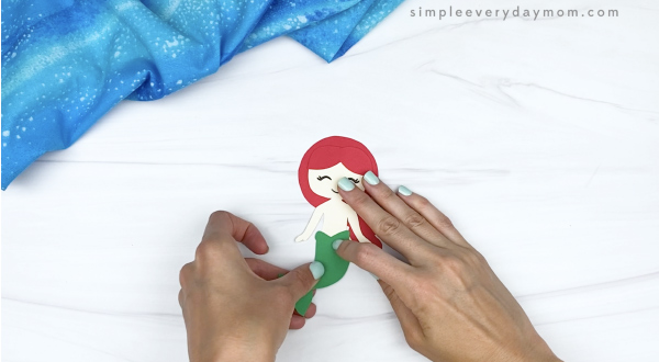 hand gluing tail to toilet paper roll mermaid craft