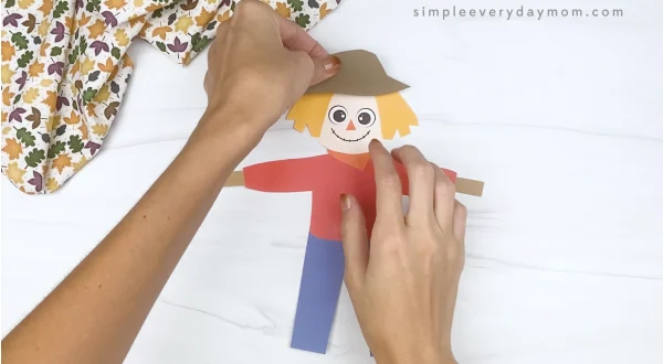 hand gluing hat to printable scarecrow craft