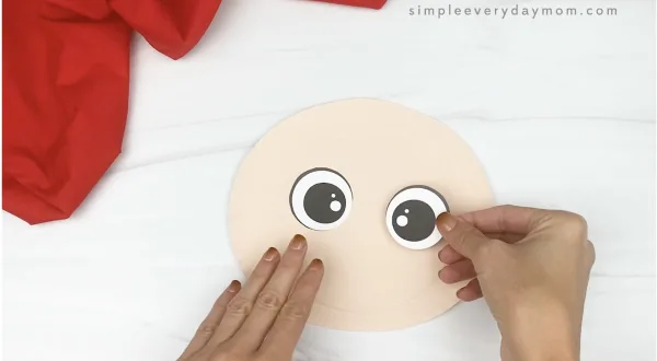 hand gluing eyes to paper plate scarecrow craft