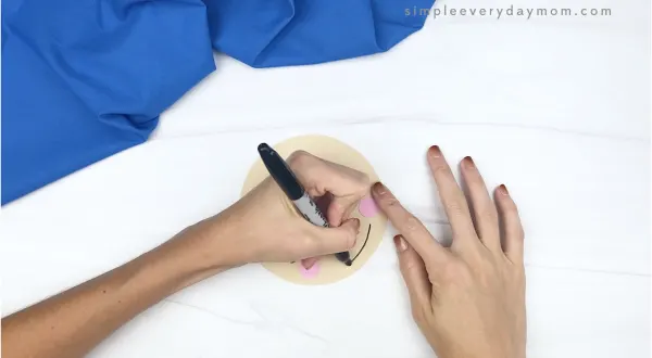 hand drawing mouth onto shape scarecrow craft
