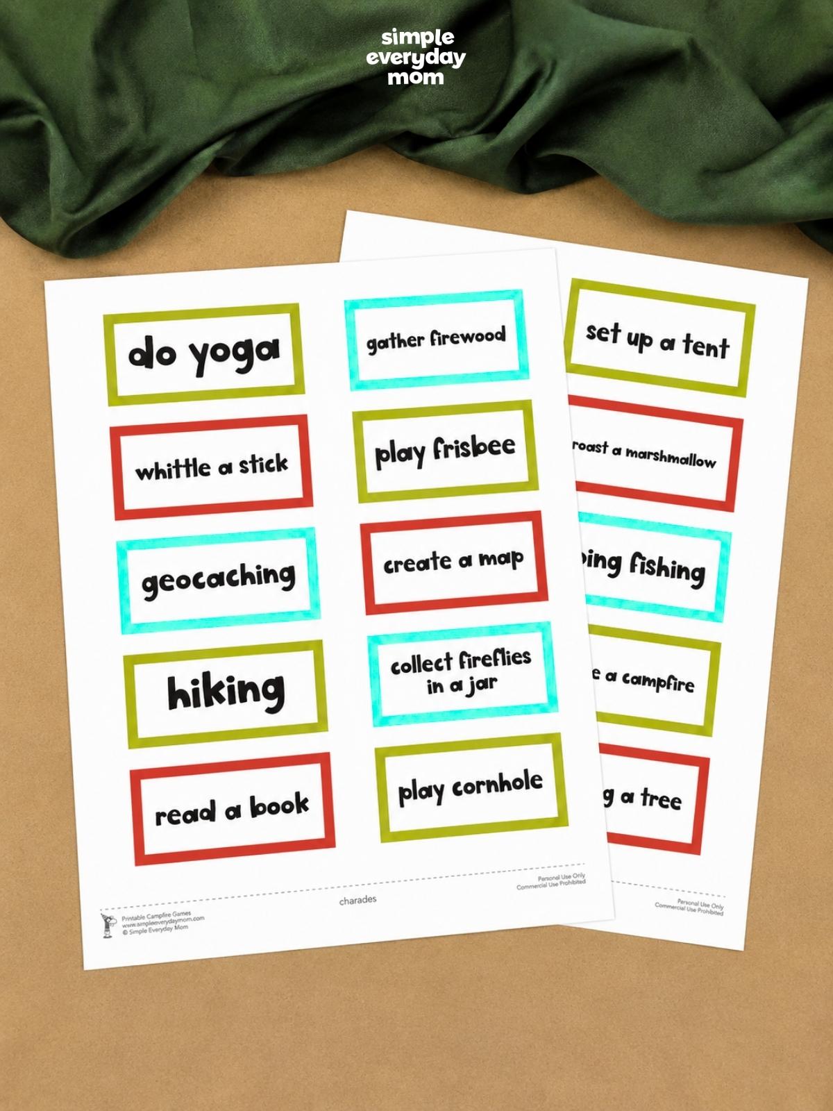 Two printable sheets of camping-themed charades cards feature activities such as hiking, gathering firewood, setting up a tent, roasting marshmallows, and playing Frisbee.