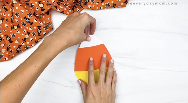 hand gluing candy corn top on