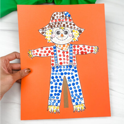 hand holding scarecrow dot art