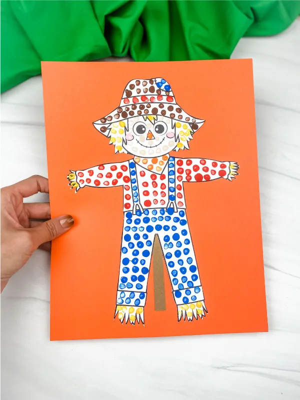 hand holding scarecrow dot art