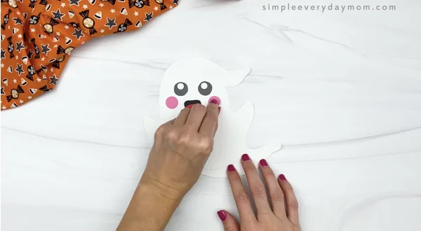 hand gluing cheek to paper plate ghost craft