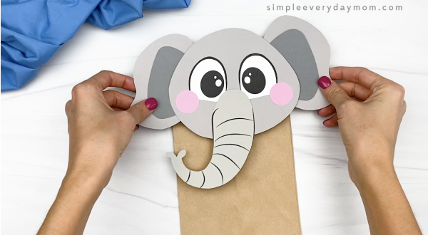 hand gluing head to paper bag elephant craft