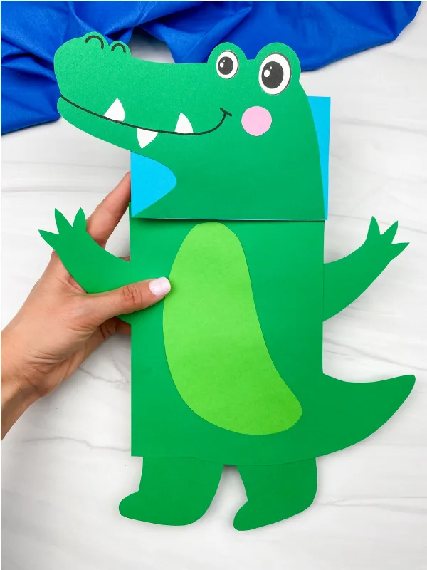 hand holding Alligator paper bag puppet craft