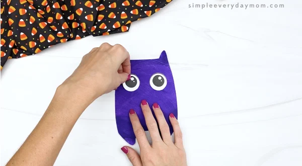 hand gluing eyes to paper plate bat craft