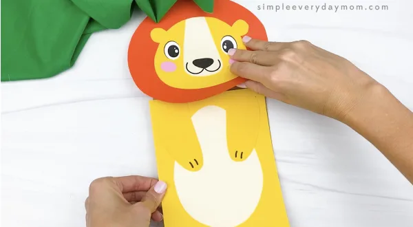 hand gluing body to paper bag lion craft