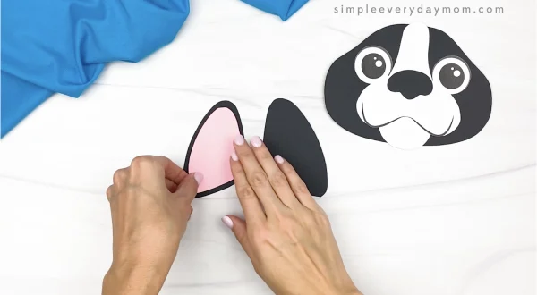 hand gluing inner ear to paper bag dog craft