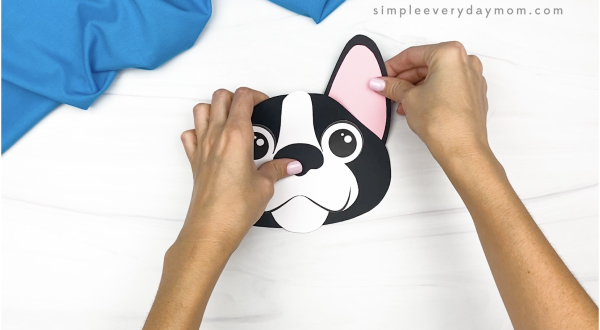 hand gluing ear to paper bag dog craft