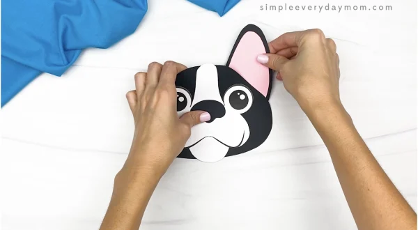 hand gluing ear to paper bag dog craft