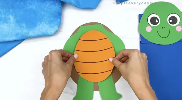 hand gluing belly to paper bag turtle craft