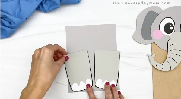 hand gluing legs to paper bag elephant craft