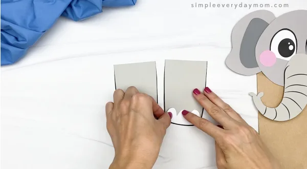 hand gluing toes to paper bag elephant craft