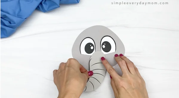 hand gluing trunk to paper bag elephant craft