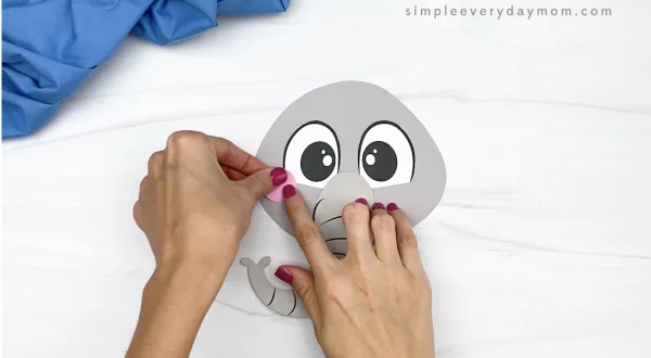 hand gluing cheeks to paper bag elephant craft