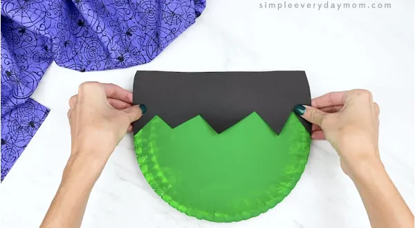 hands gluing Frankenstein hair to paper plate