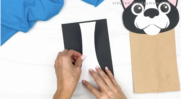 hand gluing body stripe to paper bag dog craft