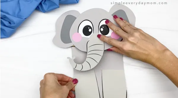 hand gluing body to paper bag elephant craft