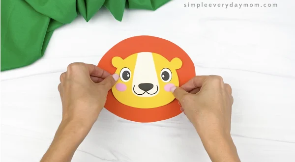 hand gluing head to mane of paper bag lion craft