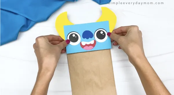 hand gluing monster head to paper bag