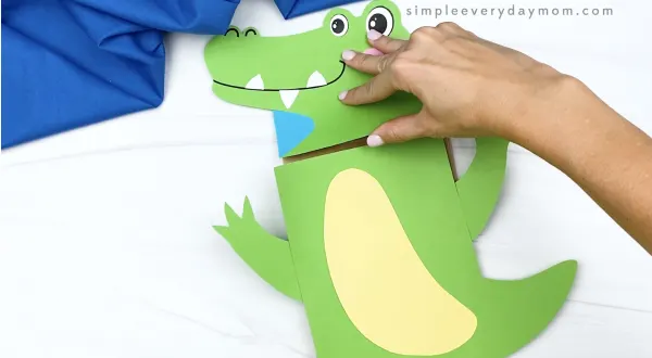 hand gluing body to paper bag alligator craft