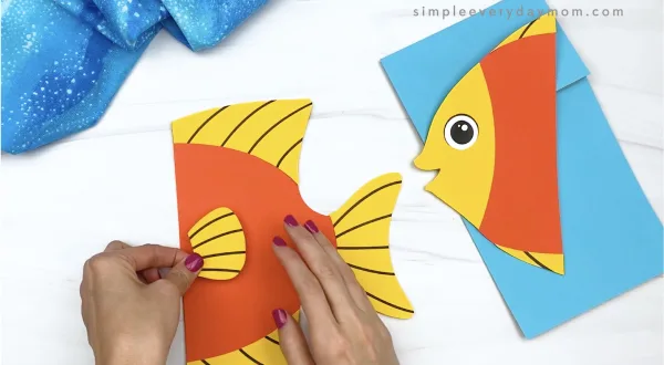 hand gluing fin to paper bag fish craft