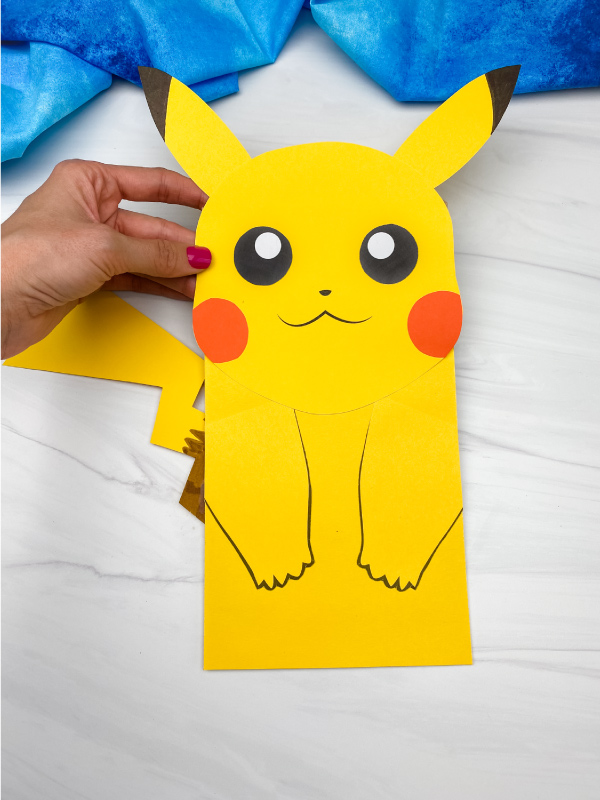hand holding paper bag Pikachu craft