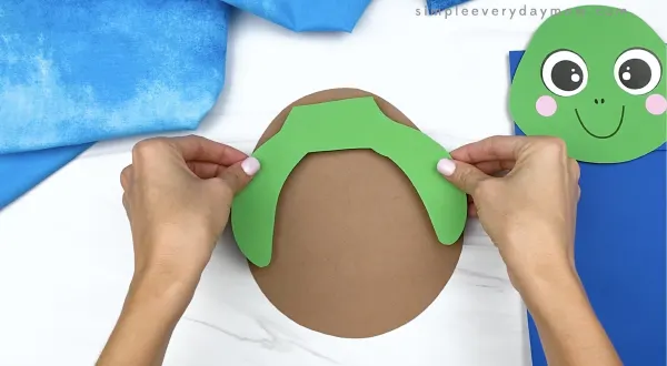 hand gluing arms to paper bag turtle craft