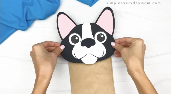 hand gluing head to paper bag dog craft