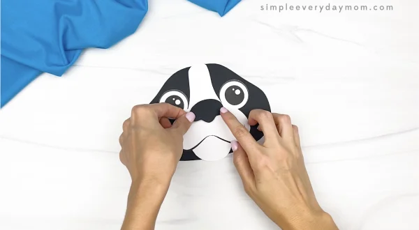 hand gluing nose to paper bag dog craft