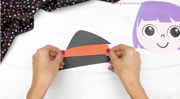 hand gluing hat band to printable witch craft