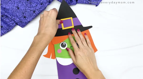 hand gluing hat to paper bag witch craft
