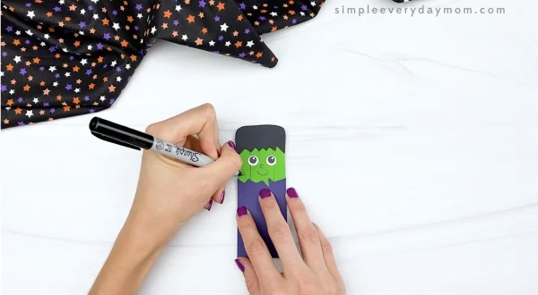 hand drawing stitches onto popsicle stick Frankenstein craft