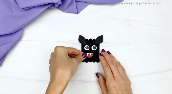 hand gluing mouth to popsicle stick bat craft