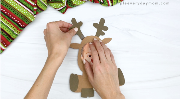 hand gluing antlers to reindeer photo craft