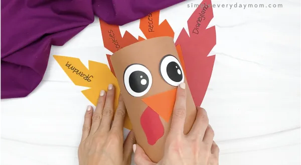 hand gluing feathers to oatmeal turkey craft