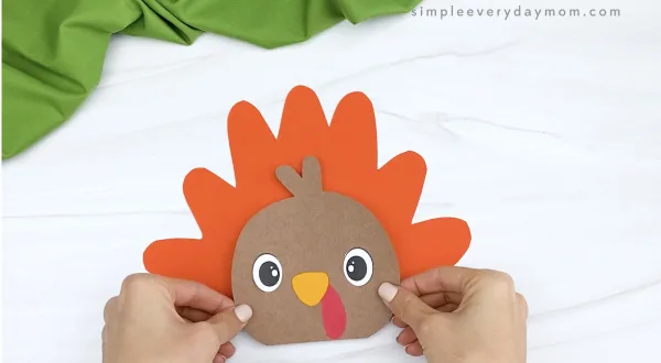 hand gluing head to feathers of turkey craftivity