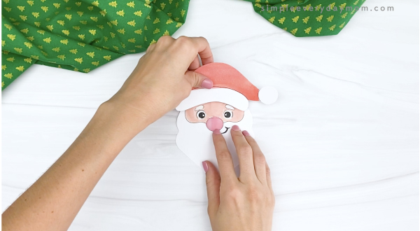 hand gluing hat to printable santa craft