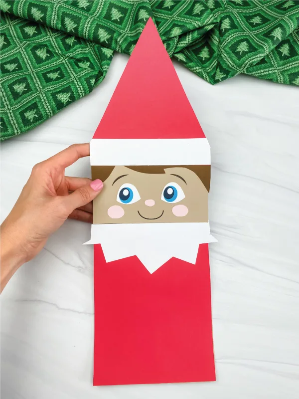 hand holding elf on the shelf paper bag craft