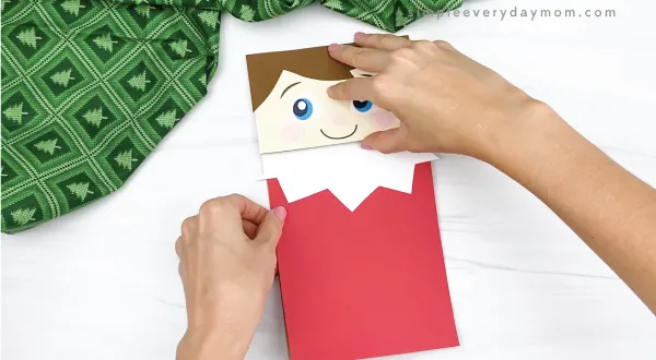 hand gluing body to elf on the the shelf puppet craft