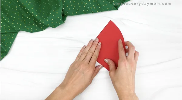 hand folding red paper in half