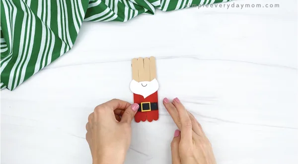 hand gluing belt to popsicle stick santa craft