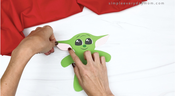hand gluing inner ear to baby Yoda gingerbread craft