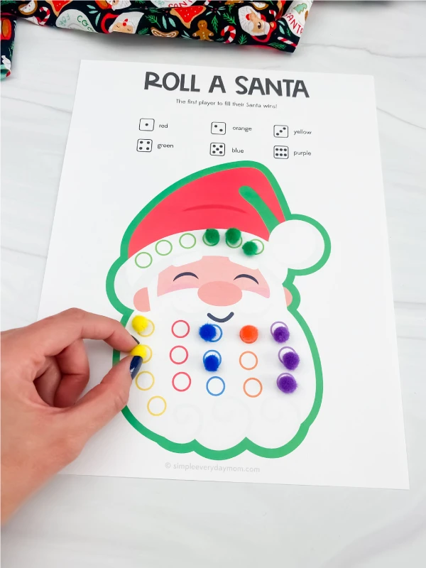 hand placing pom pom on printable Santa game