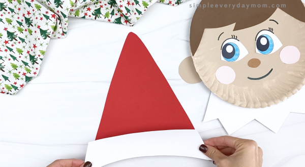 hand gluing hat fluff to elf on the shelf hat